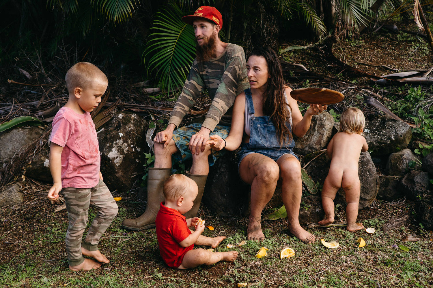 family sitting down having lunch on the floor in Maui